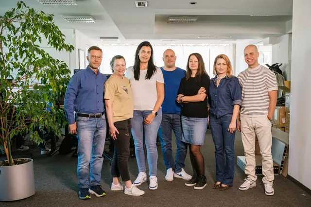 Eight eFellows colleagues standing together in the office